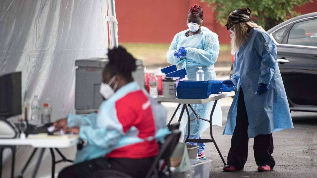 Medical personnel at StarMed Family & Urgent Care Clinic get ready to test patients July 8 at an outdoor coronavirus testing site, amid a surge in COVID cases in Mecklenburg County.