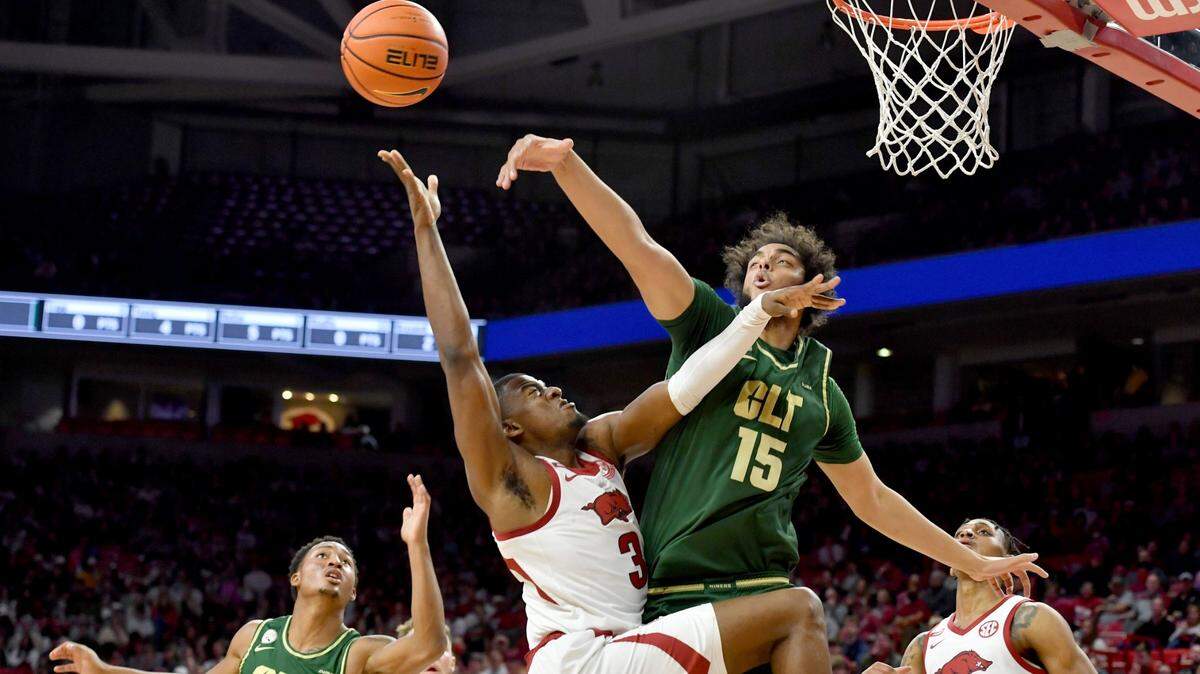 Arkansas forward Trey Wade (3) has his shot blocked by Charlotte defenders Aly Khalifa (15) and Jahmir Young (1) during the first half of an NCAA college basketball game Tuesday, Dec. 7, 2021, in Fayetteville, Ark. (AP Photo/Michael Woods)