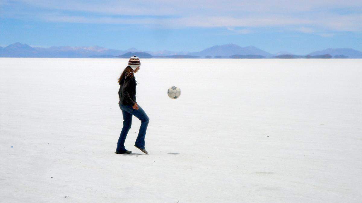 In “Pelada,” Gwendolyn Oxenham, part of the on-camera team, kicks a ball in the salt flats in Uyuni, Bolivia.