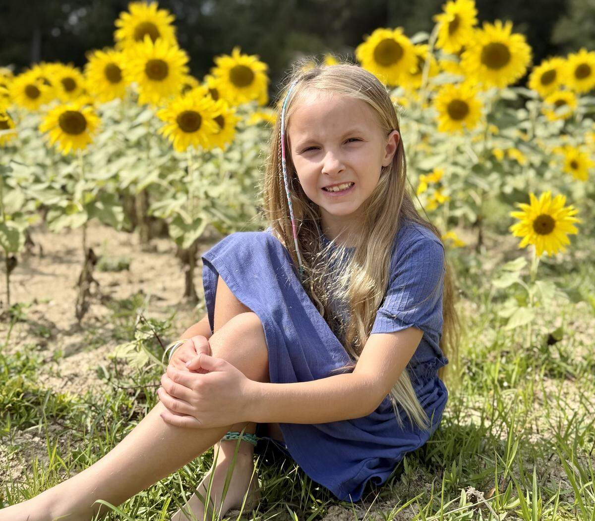 Annie Smith sits in a sunflower field near her Union County home on Sept. 16. Her father suggested taking the photo.