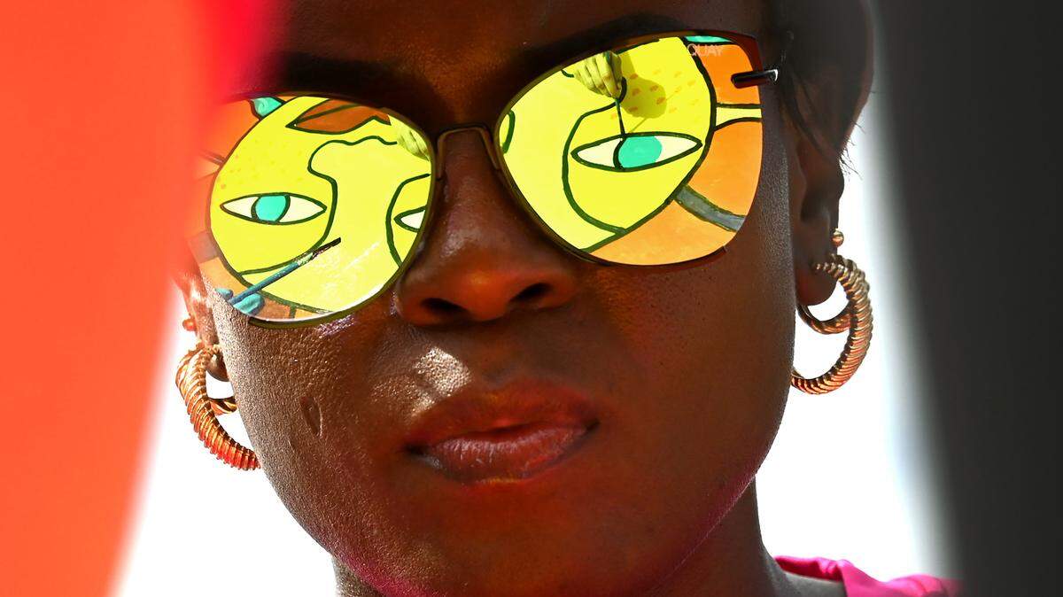 The mural Rays of Sunshine is reflected in the sunglasses of Jo’Nay Prioleau, an employee with Carolina Complete Health on Friday, April 19, 2024. Prioleau and her co-workers joined employees from other local companies for the 19th Charlotte Playground Build at Westerly Hills Academy. The playground build is presented by United Way of Greater Charlotte that brings together companies across the community to build a new playground for a local Charlotte-Mecklenburg elementary school.