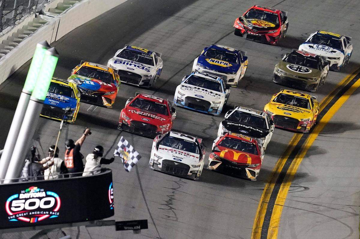 Austin Cindric (2) beats Bubba Wallace (23) to the checkered flag to win the NASCAR Daytona 500 auto race Sunday, Feb. 20, 2022, at Daytona International Speedway in Daytona Beach, Fla. (AP Photo/David Graham)