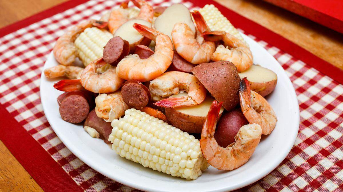 Low-country shrimp boil, a popular seafood dish in the southern United States, featuring shrimp, smoked sausage, red potatoes and corn on the cob