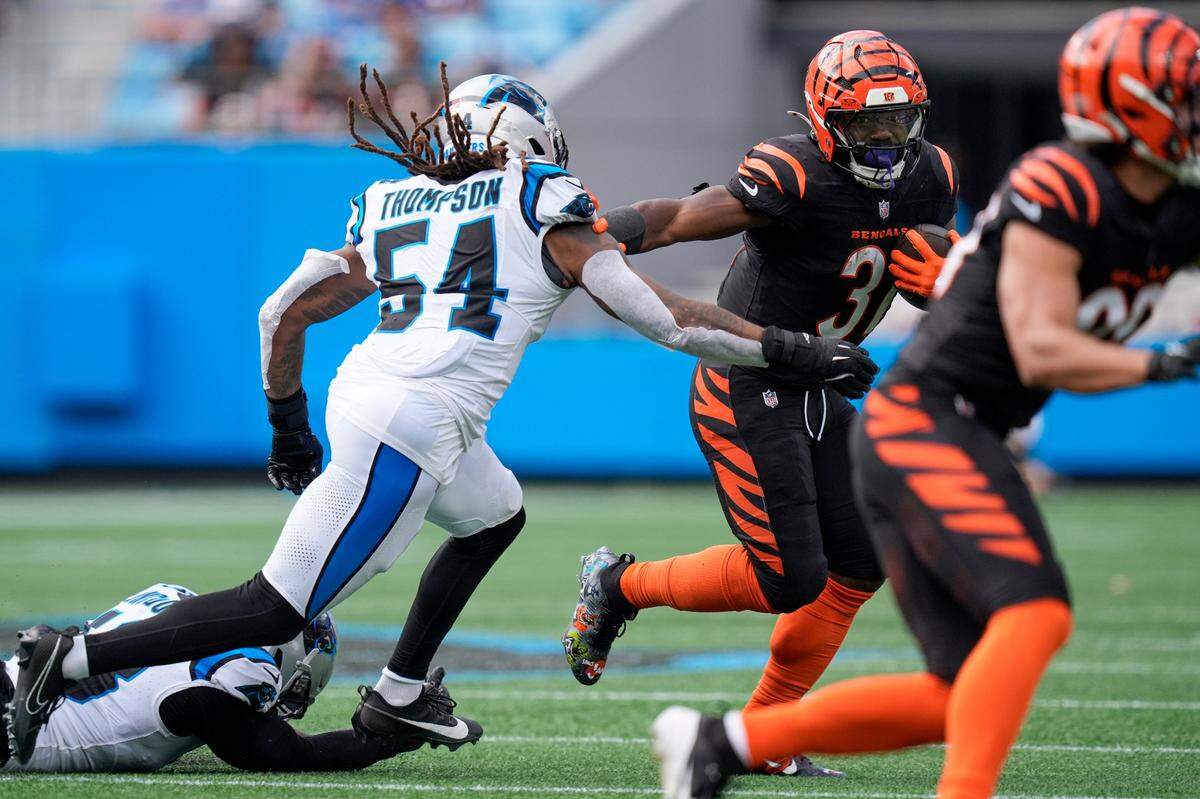 Cincinnati Bengals running back Zack Moss (31) tries to elude Carolina Panthers linebacker Shaq Thompson (54) during Sunday’s third quarter at Bank of America Stadium.