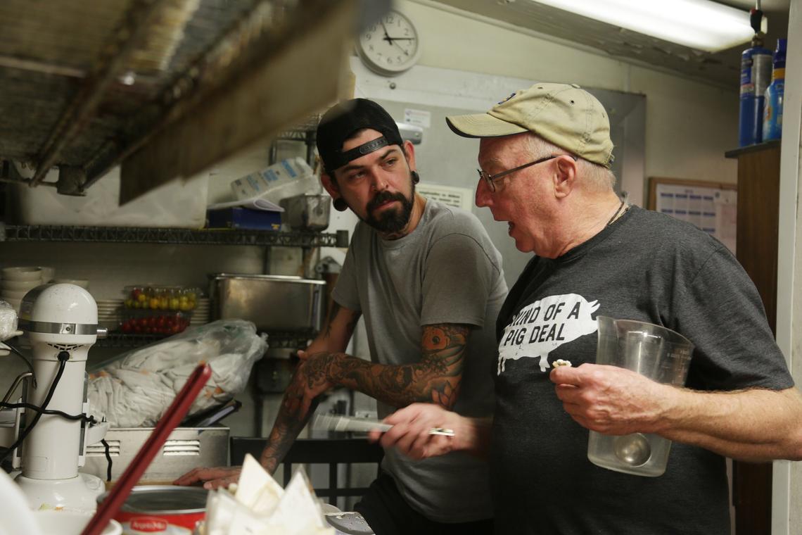 Chef Bill Smith, right, looks over a recipe with chef Justin Burdett in the kitchen at Crook’s Corner in Chapel Hill on Thursday, Oct. 4, 2018. Burdett will replace Smith, who will be stepping down as executive chef of the restaurant in January.