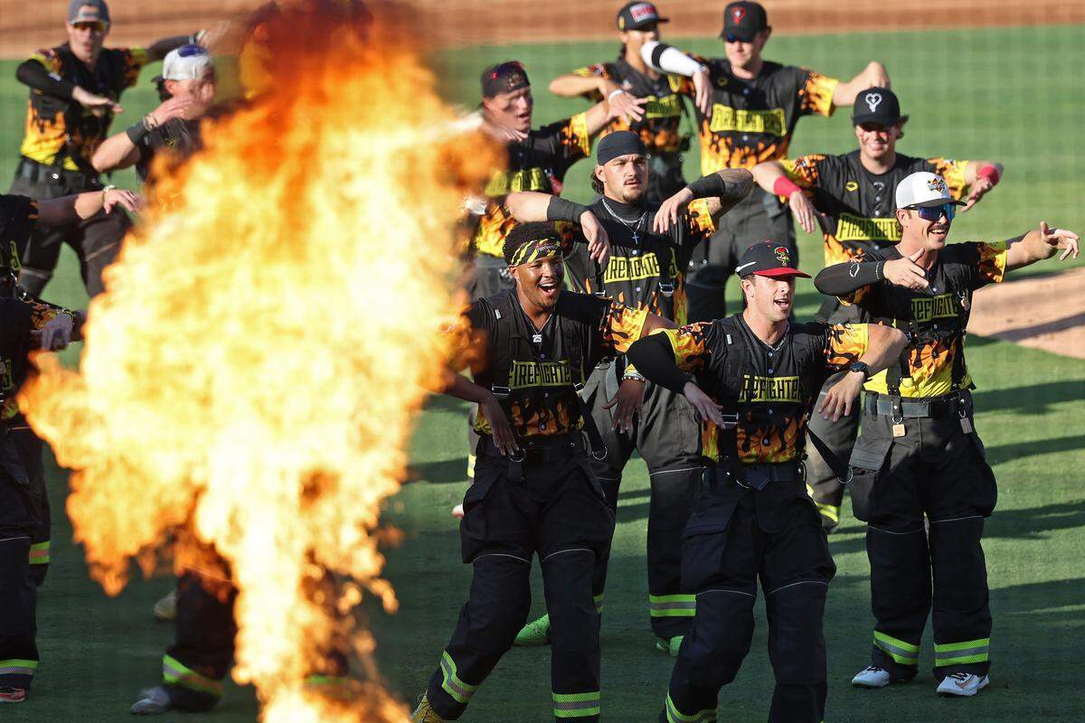 Members of the Firefighters dance as flames fill the air along the baselines of Truist Field in Charlotte, NC on Thursday, June 4, 2026. Banana Ball action returned to the Queen City with the Texas Tailgaters battling the Firefighters.