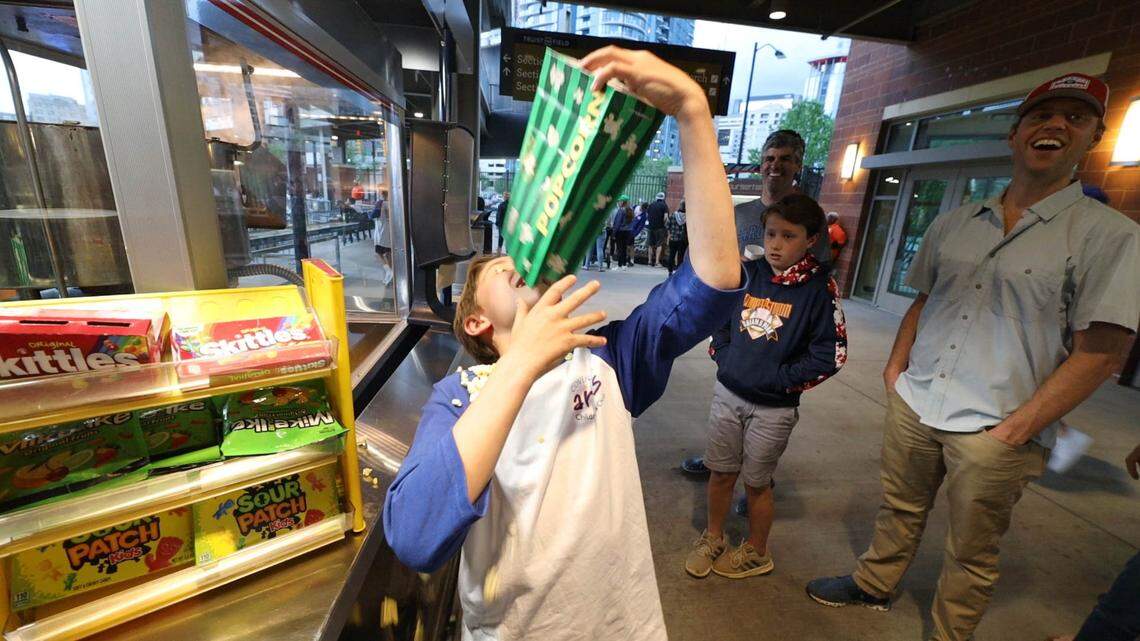 Whether you’re a kid or an adult kid, ballpark food is always exciting. Show up hungry to your next Charlotte Knights baseball game at Truist Field. Above, Cooper Kidd enjoys the ballpark popcorn.