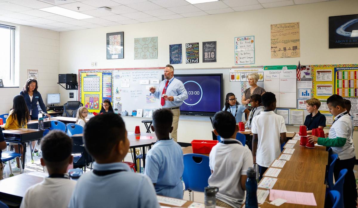 Thurs grade teacher Paul Michael Williams works with students on an exercise during the first day of school at Idlewild Elementary School in Charlotte, NC on Monday, August 26, 2024.