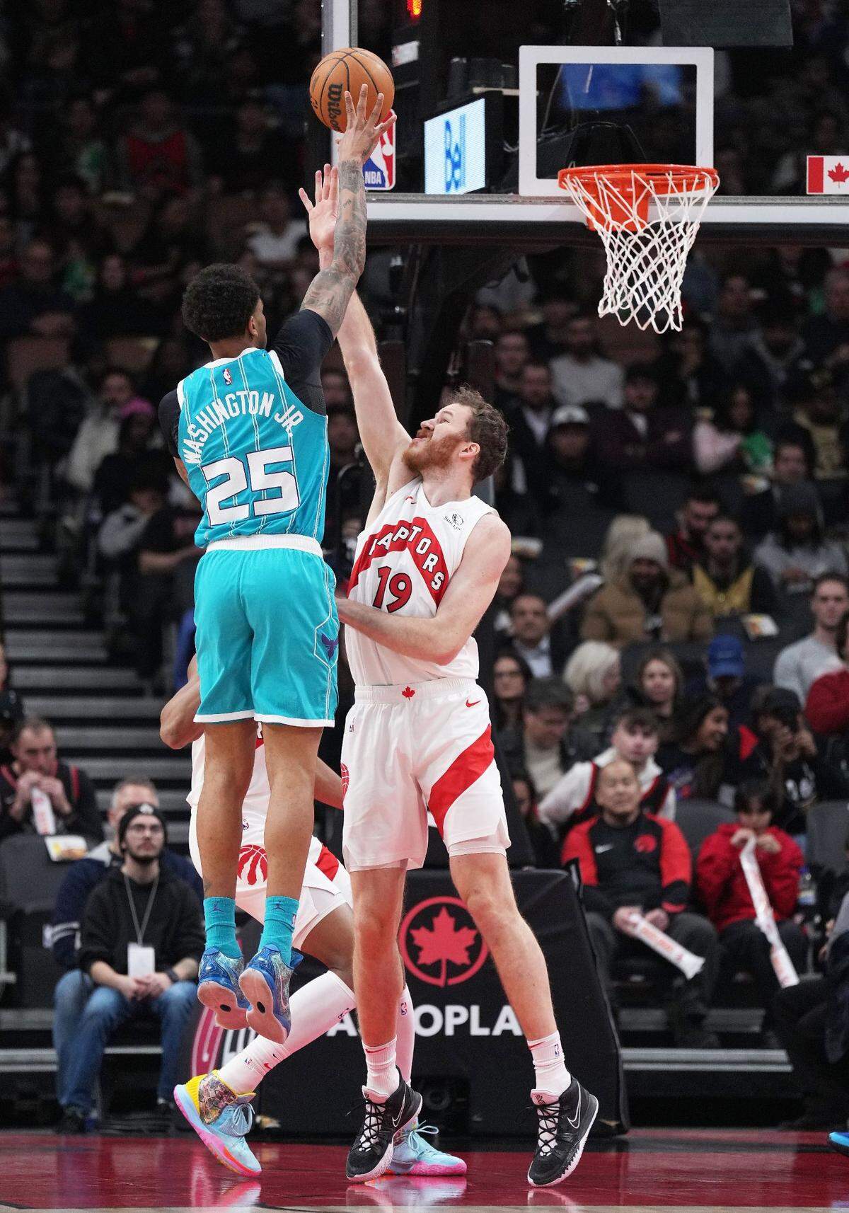 Charlotte Hornets forward P.J. Washington (25) shoots the ball at the basket as Toronto Raptors center Jakob Poeltl (19) tries to defend during the first quarter at Scotiabank Arena.