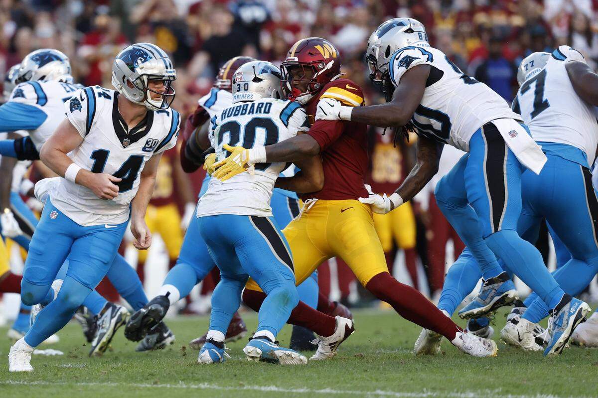 Oct 20, 2024; Landover, Maryland, USA; Washington Commanders linebacker Dante Fowler Jr. (6) tackles Carolina Panthers running back Chuba Hubbard (30) on an attempted fourth down conversion during the second quarter at Northwest Stadium. Mandatory Credit: Geoff Burke-Imagn Images