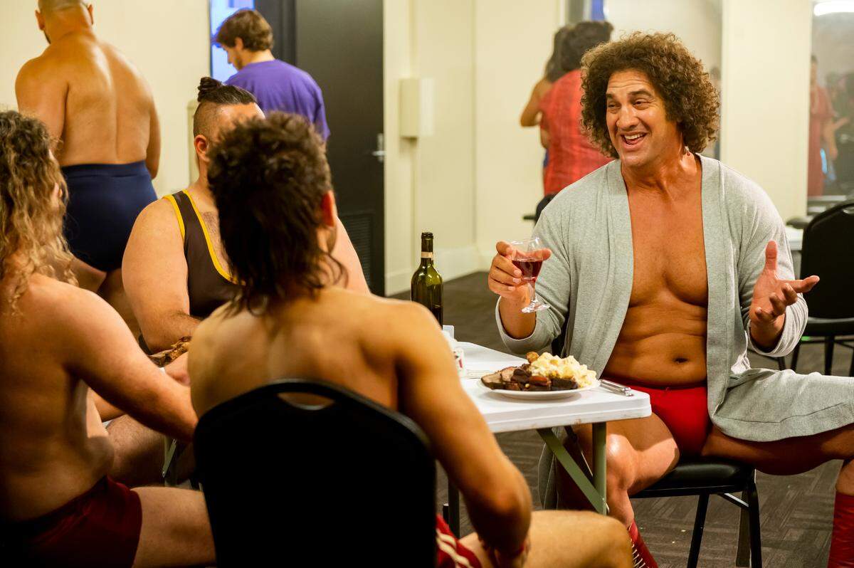 Former Carolina Panther Matt Willig (far right), playing Andre the Giant, talks with several other pro wrestlers on the NBC comedy “Young Rock,” which airs on Tuesdays at 8 p.m.