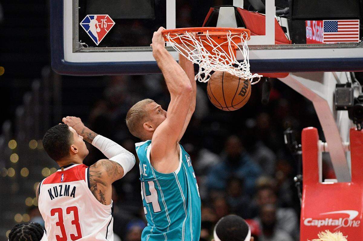 Charlotte Hornets center Mason Plumlee (24) dunks past Washington Wizards forward Kyle Kuzma (33) during the first half of an NBA basketball game, Monday, Nov. 22, 2021, in Washington. (AP Photo/Nick Wass)