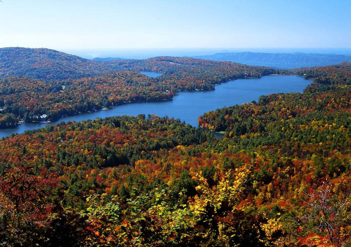 An aerial view showcases Lake Toxaway during peak leaf season.