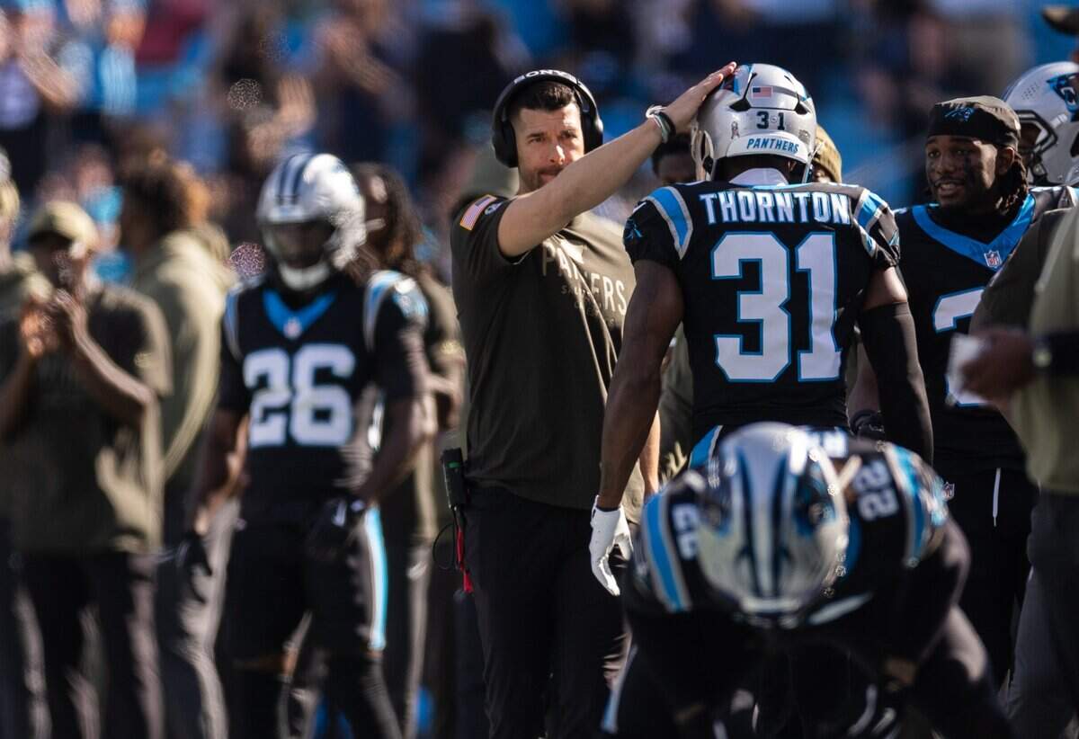 Carolina Panthers coach Dave Canales, left, pats Carolina Panthers cornerback Corey Thornton on the head as he stands on the sideline at Bank of America Stadium in Charlotte, North Carolina., on Sunday, Nov. 9, 2025.