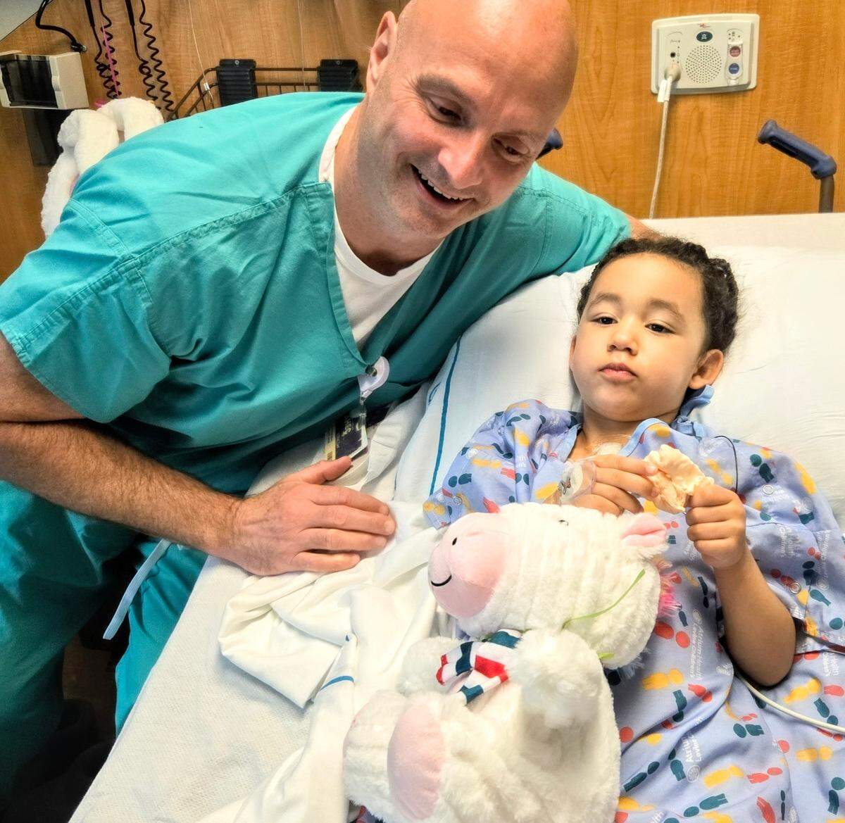 Atrium Health pediatric surgeon Thomas Maxey checks in on Aria Horne after her surgery earlier this month.