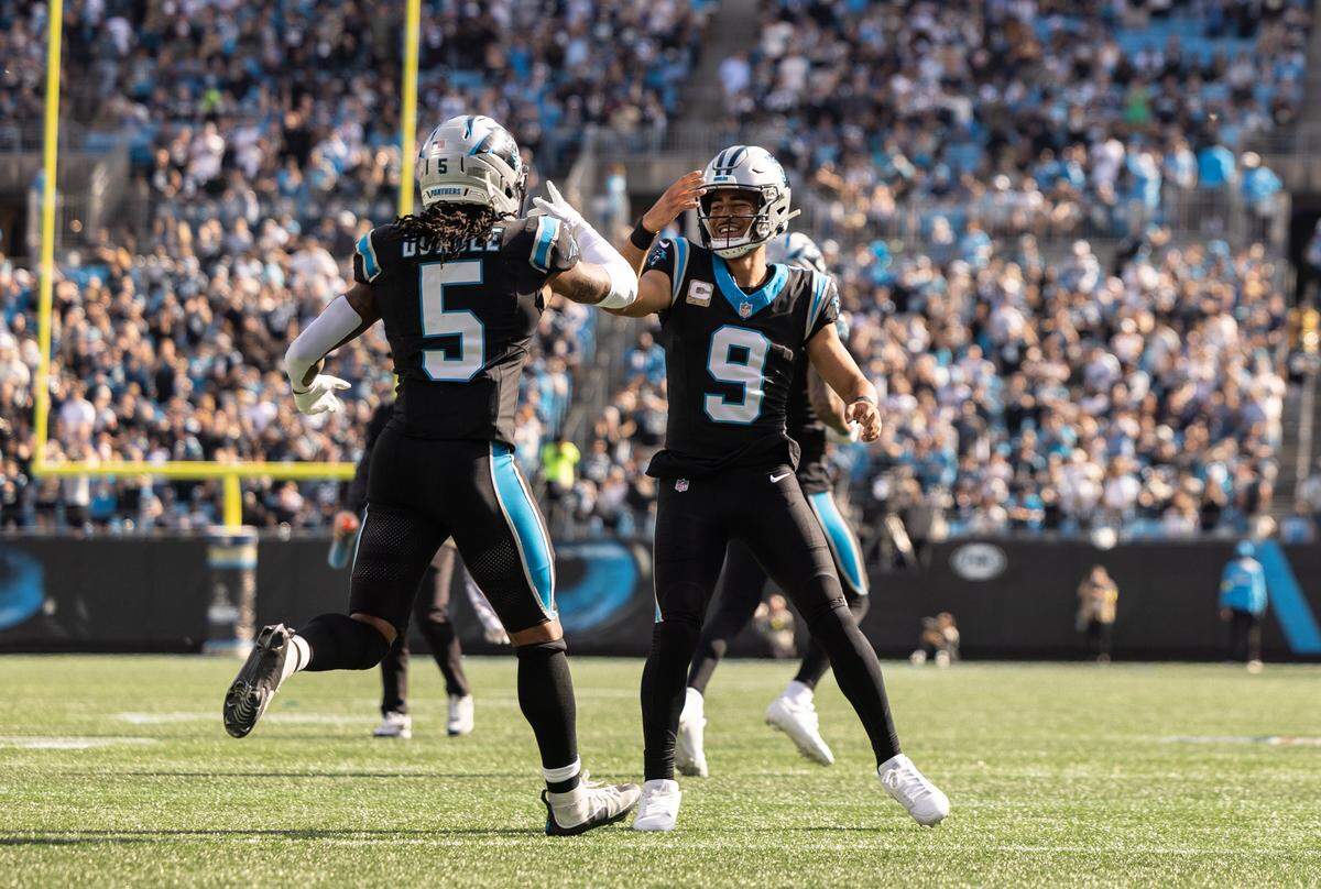 Carolina Panthers quarterback Bryce Young, right, celebrates a touchdown with Carolina Panthers running back Rico Dowdle at The Bank of America Stadium in Charlotte, N.C., on Sunday, November 9, 2025.