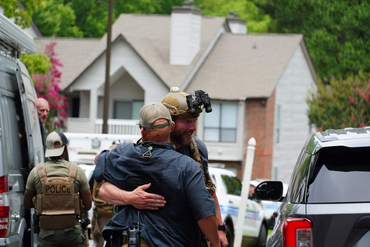 CMPD SWAT officer hugging a colleague after searching for an individual.