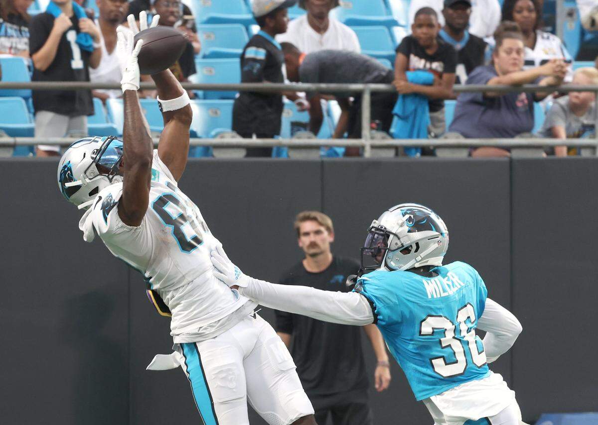 Carolina Panthers wide receiver Terrace Marshall, left, leaps into the air to catch a pass in the end zone as cornerback Herb Miller, right, defends during the team’s Fan Fest practice at Bank of America Stadium on Wednesday, August 2, 2023.