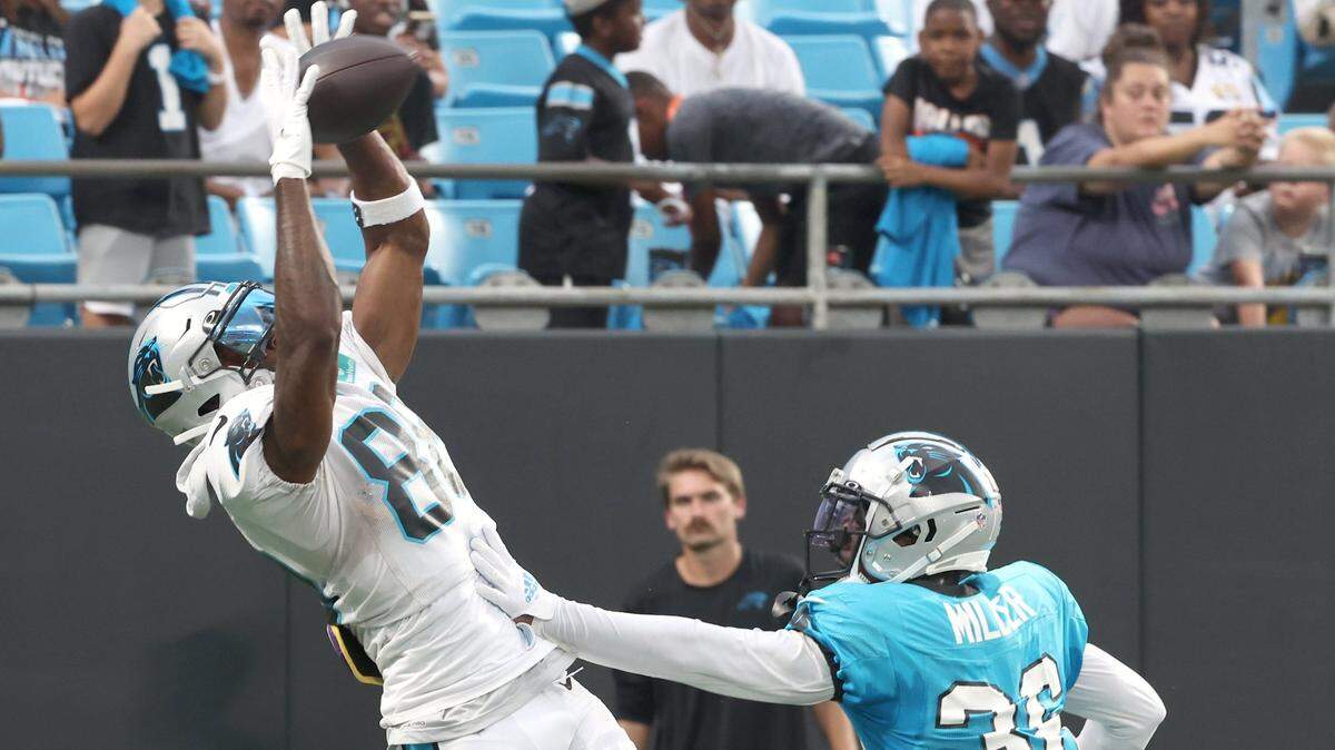 Carolina Panthers wide receiver Terrace Marshall, left, leaps into the air to catch a pass in the end zone as cornerback Herb Miller, right, defends during the team’s Fan Fest practice at Bank of America Stadium on Wednesday, August 2, 2023.