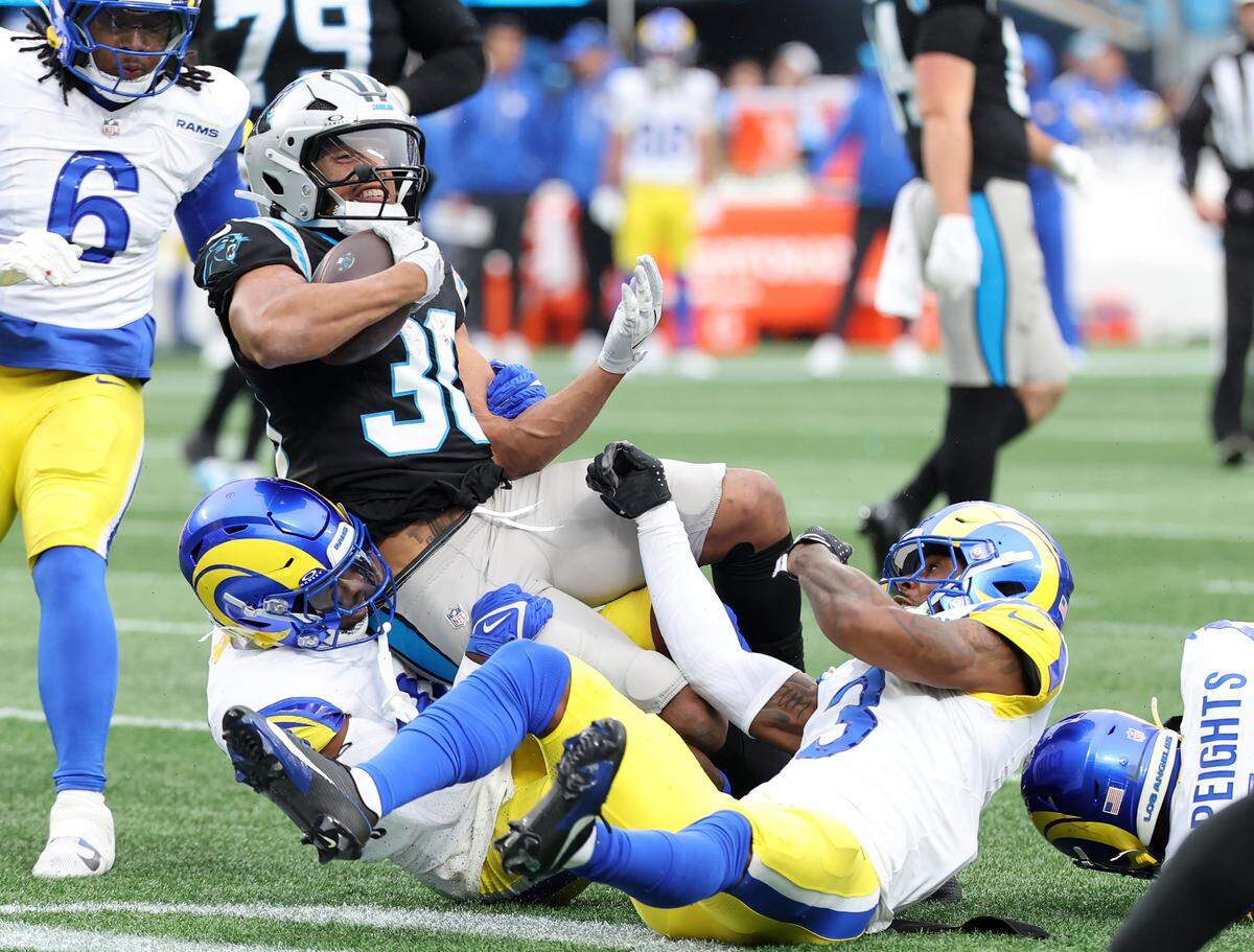 Carolina Panthers' Chubba Hubbard is tackled in the first half of the game against the Los Angeles Rams on Sunday, Nov. 30, 2025 in Charlotte.