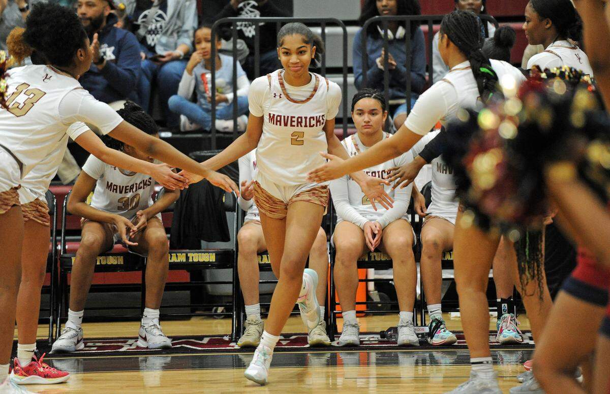 Mallard Creek’s My’Asia Young, center, exchanges high fives with her teammates during pre-game introductions for the Queen City 3A/4A tournament girls championship game against North Mecklenburg on Friday, Feb. 23, 2024, at Harding University High School in Charlotte, N.C. (CREDIT: BILL KISER/SPECIAL TO THE OBSERVER)