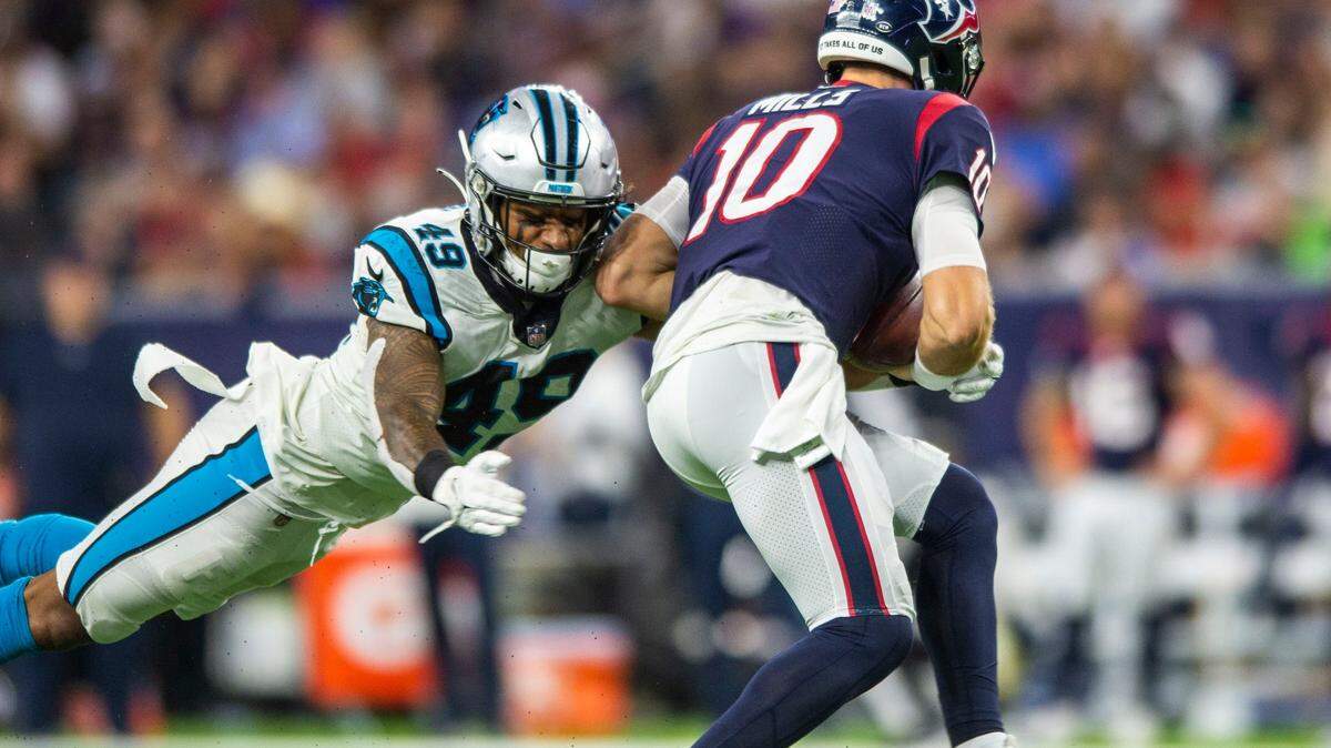 Panthers linebacker Frankie Luvu, left, lunges toward Texans  quarterback Davis Mills during the game at NRG Stadium on Thursday, September 21, 2021 in Houston, TX. The Panthers beat the Texans 24-9, giving them their third win in a row to start the season.