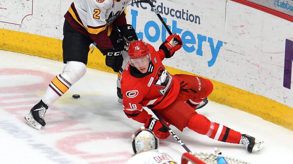 Charlotte Checkers center Morgan Geekie, right, falls to the ice while battling Chicago Wolves Nic Hague, left, for the puck during 2019 Calder Cup Final at Bojangles’ Coliseum in Charlotte, NC.