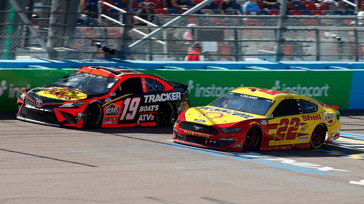 Martin Truex Jr (19) and Joey Logano (22) race through Turn 4 during a NASCAR Cup Series auto race at Phoenix Raceway, Sunday, March 14, 2021, in Avondale, Ariz. (AP Photo/Ralph Freso)