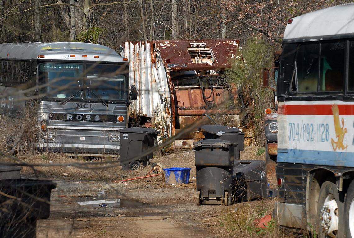 In this 2007 Charlotte Observer file photo, wrecked cars, old buses and mobil toters clutter an empty lot beside a home that was used for storage on Burton Lane in the Smithville community in Cornelius, NC.