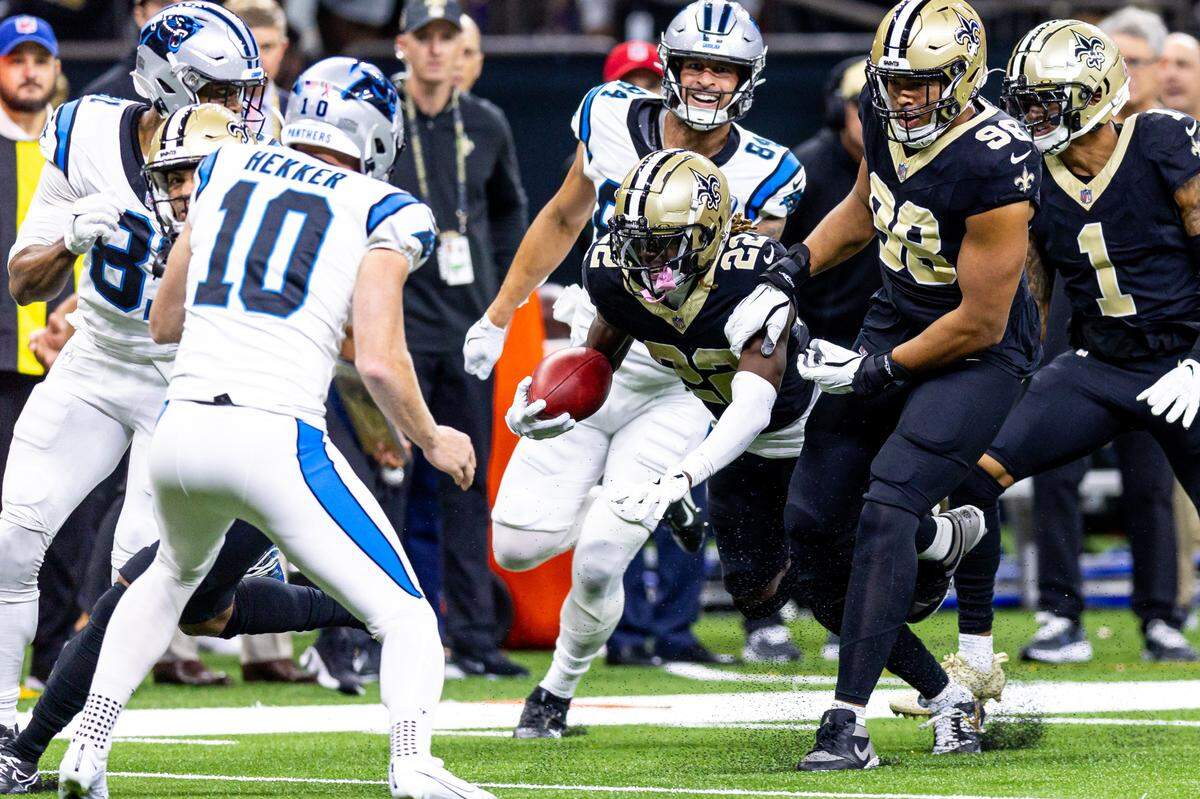 New Orleans Saints wide receiver Rashid Shaheed (22) is tripped on a run back by Carolina Panthers tight end Feleipe Franks (84) during the first half at Caesars Superdome.