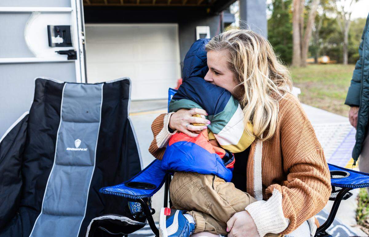 Says Rebecca Fennel, a Riverside Drive resident photographed hugging her son Declan next to a borrowed RV in their driveway last November: “There’s a lot of people here whose lives are completely destroyed by this, and they deserve just as much support” as Helene victims in the mountains.