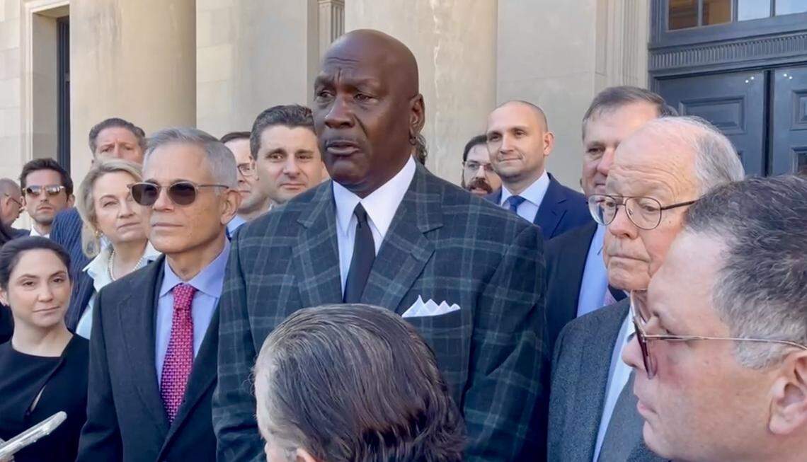 Michael Jordan (center) speaks to reporters on the courthouse steps in Charlotte following the settlement of his lawsuit against NASCAR on Thursday, Dec. 11, 2025. To the right of Jordan is NASCAR CEO Jim France. The settlement followed eight days of testimony.