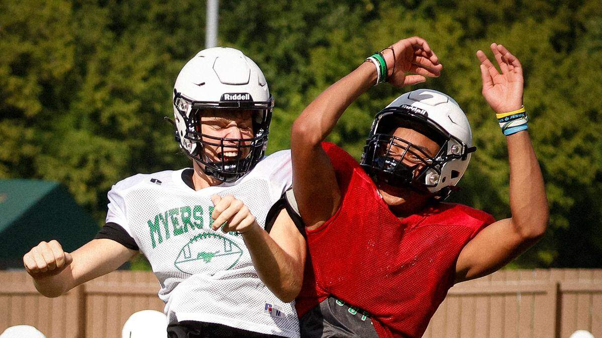 Myers Park safety Tommy Sullivan, left, and quarterback Brock Jenkins celebrate on the field during practice at Myers Park High School in Charlotte, N.C., Monday, Aug. 8, 2022.