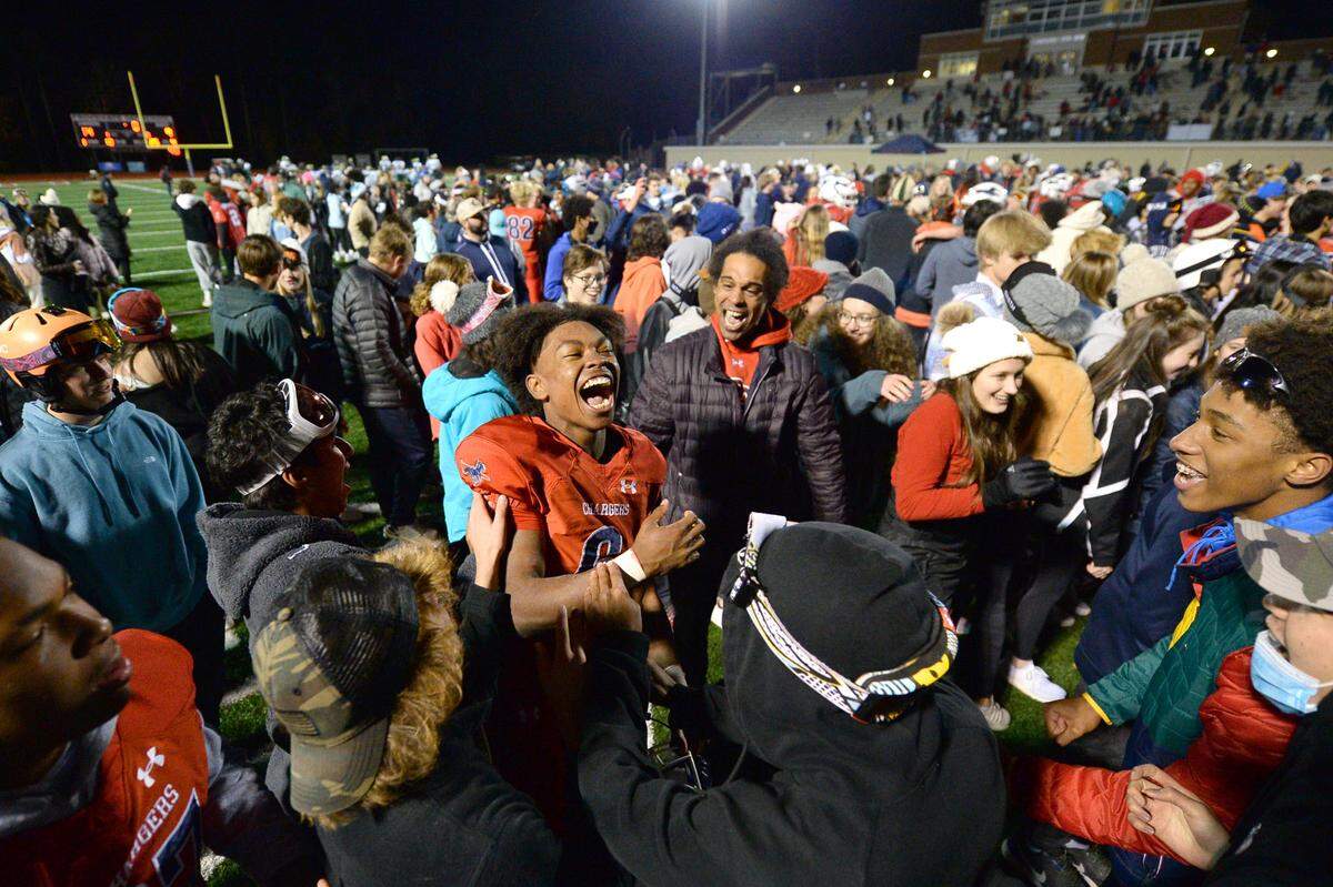 Providence Day Chargers defensive back Braxton Winston, center, is congratulated by classmates following the team’s 14-9 victory over Rabun Gap at Providence Day School in Charlotte, NC on Friday, November 19, 2021. The Chargers defeated Rabun Gap to win the NCISAA boys state championship game.