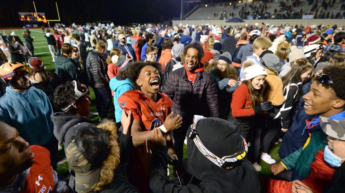 Providence Day Chargers defensive back Braxton Winston, center, is congratulated by classmates following the team’s 14-9 victory over Rabun Gap at Providence Day School in Charlotte, NC on Friday, November 19, 2021. The Chargers defeated Rabun Gap to win the NCISAA boys state championship game.