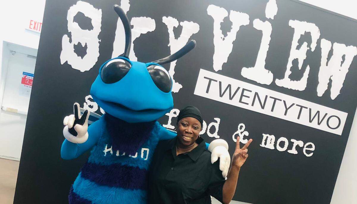 Skyview 22 owner Sharnette King with Hugo, the Charlotte Hornets mascot.
