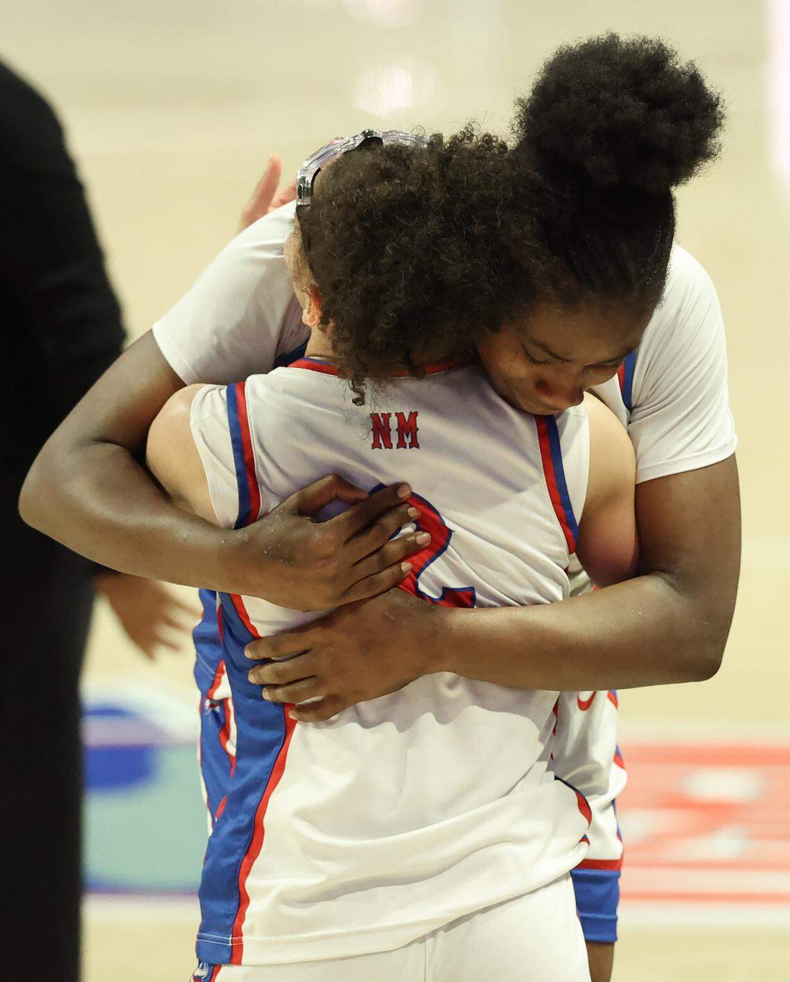 North Meck’s Stephanie Mobley, back to camera and Lenise Joseph, facing camera, hug as they celebrate the team’s 65-38 win over Southern Durham in the NCHSAA 7A girls championship game on Saturday, March 14, 2026 at Lawrence Joel Veterans Memorial Coliseum in Winston-Salem, NC.