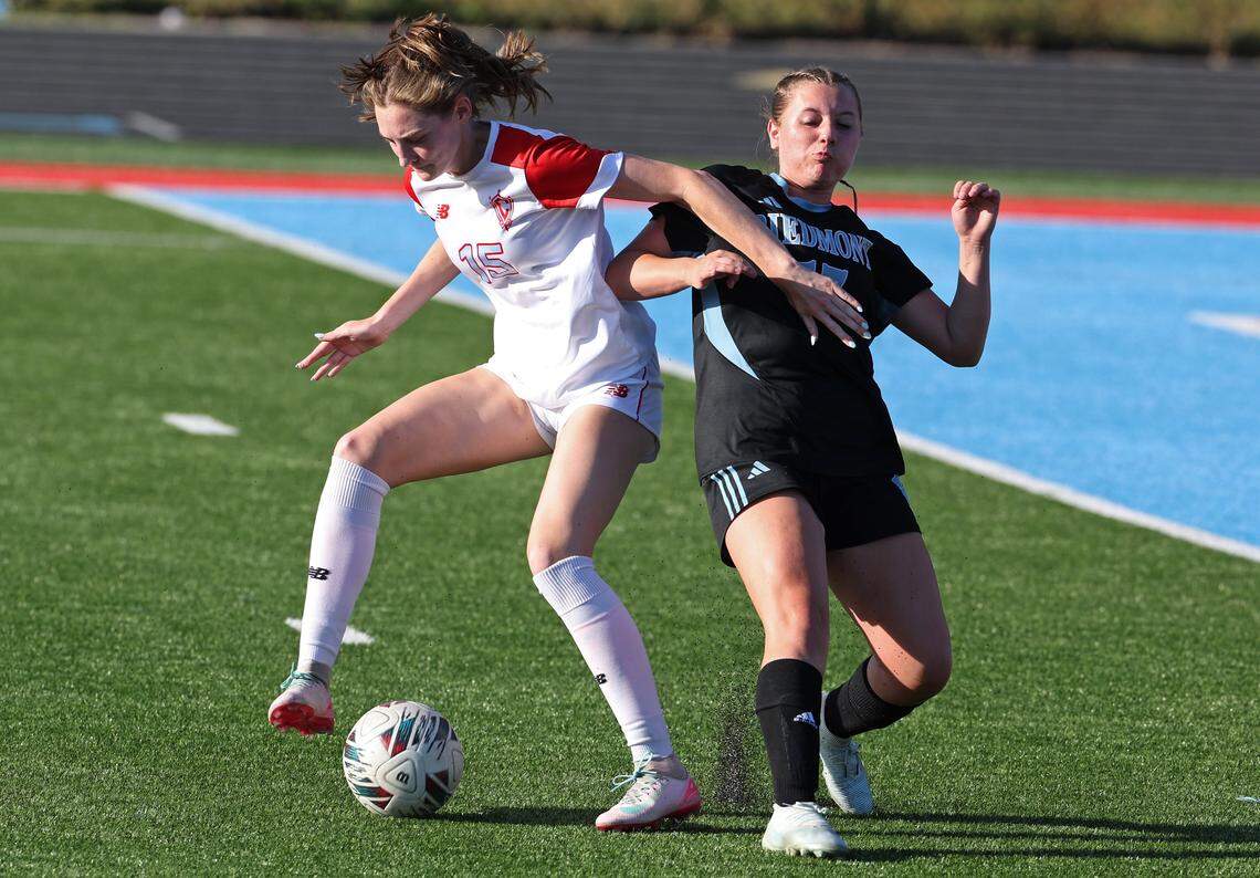 Charlotte Catholic’s Marguerite McPhillips, left, fights to maintain control of the ball from Piedmont’s Lillian Ponscheck on Wednesday, April 15, 2026. Charlotte Catholic’s girls soccer team is ranked No. 4 in the nation by MaxPreps.