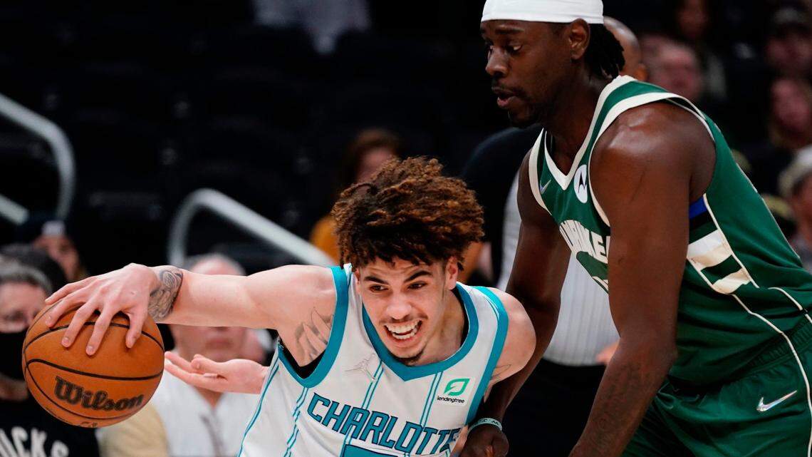 Charlotte Hornets’ LaMelo Ball drives past Milwaukee Bucks’ Jrue Holiday during the first half of an NBA basketball game Monday, Feb. 28, 2022, in Milwaukee . (AP Photo/Morry Gash)