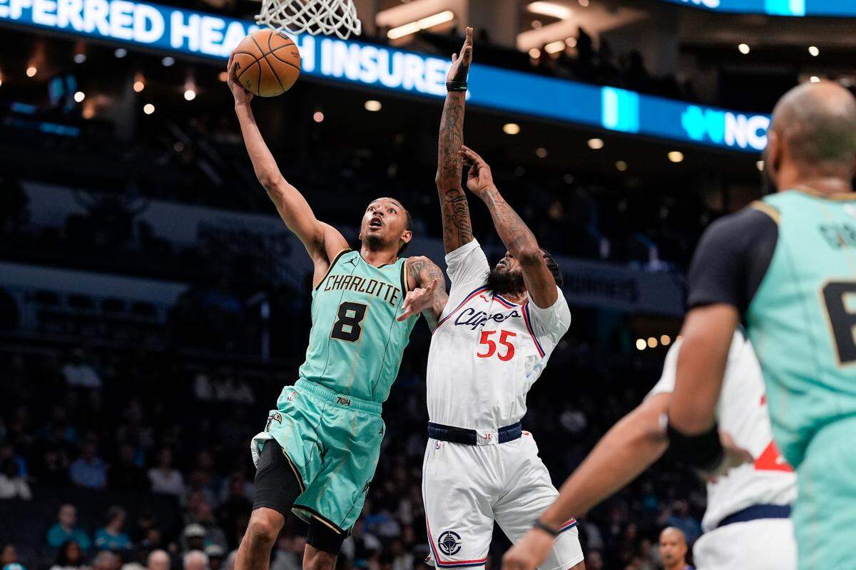 Charlotte Hornets guard Nick Smith Jr. (8) makes a layup defended by LA Clippers forward Derrick Jones Jr. (55) during the first quarter at Spectrum Center.
