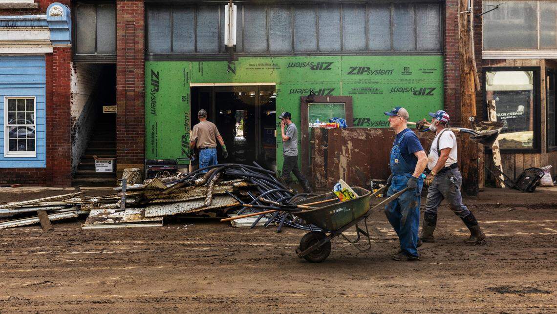 Residents and volunteers clean up on Tuesday, Oct. 1, 2024 after the French Broad River flooded downtown Marshall. The remnants of Hurricane Helene caused widespread flooding, downed trees, and power outages in western North Carolina.