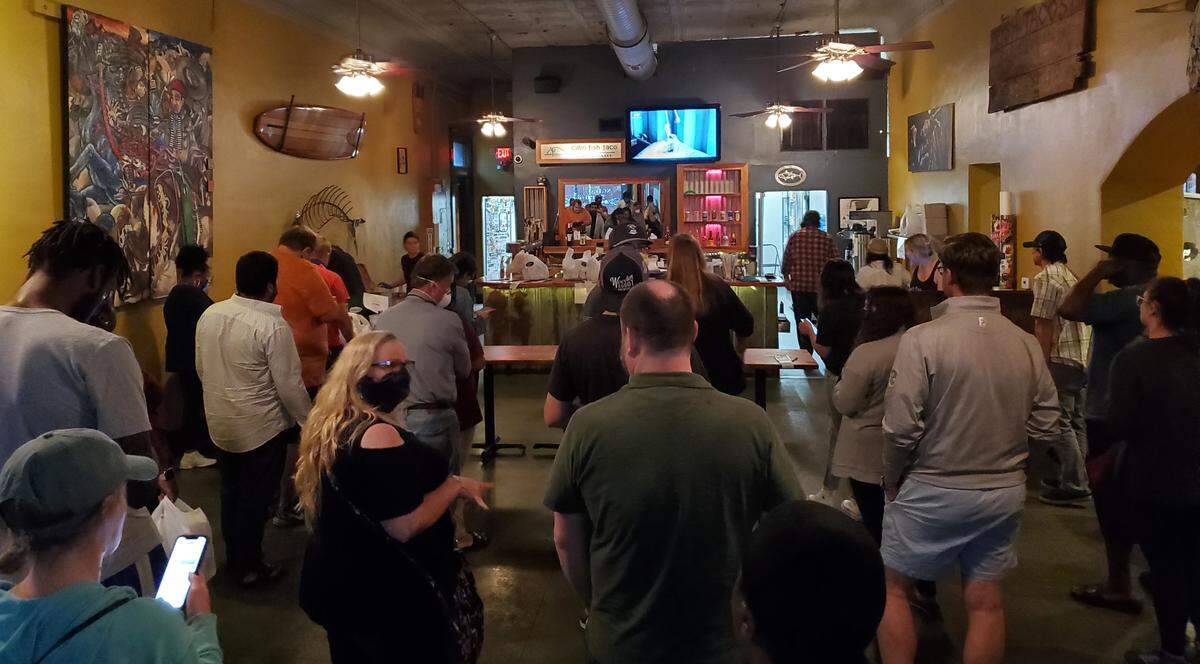 Free drinks helped lighten the mood as crowds waited Tuesday night at Cabo Fish Taco with little social distancing.