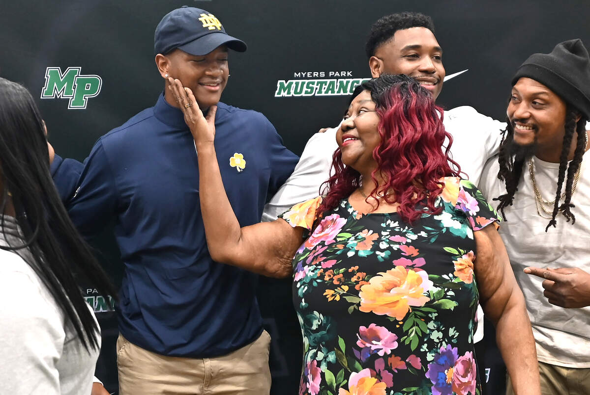 Crystal Chavers, center, cradles her grandson, Rodney Dunham’s face in her hand following his announcement that he will be attending Notre Dame. Dunham a Top 10 national football recruit had narrowed down his choices to Duke, South Carolina, Georgia, Tennessee and Notre Dame.