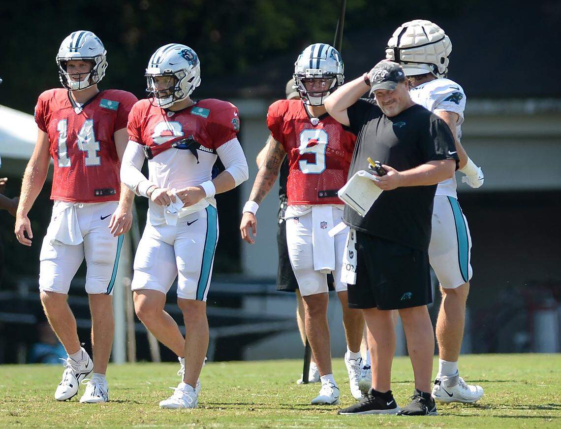 (L-R) Carolina Panthers quarterbacks Sam Darnold, Baker Mayfield and Matt Corral watch a drill with offensive coordinator Ben McAdoo during practice on Monday, August 8, 2022 at Wofford College in Spartanburg, SC.