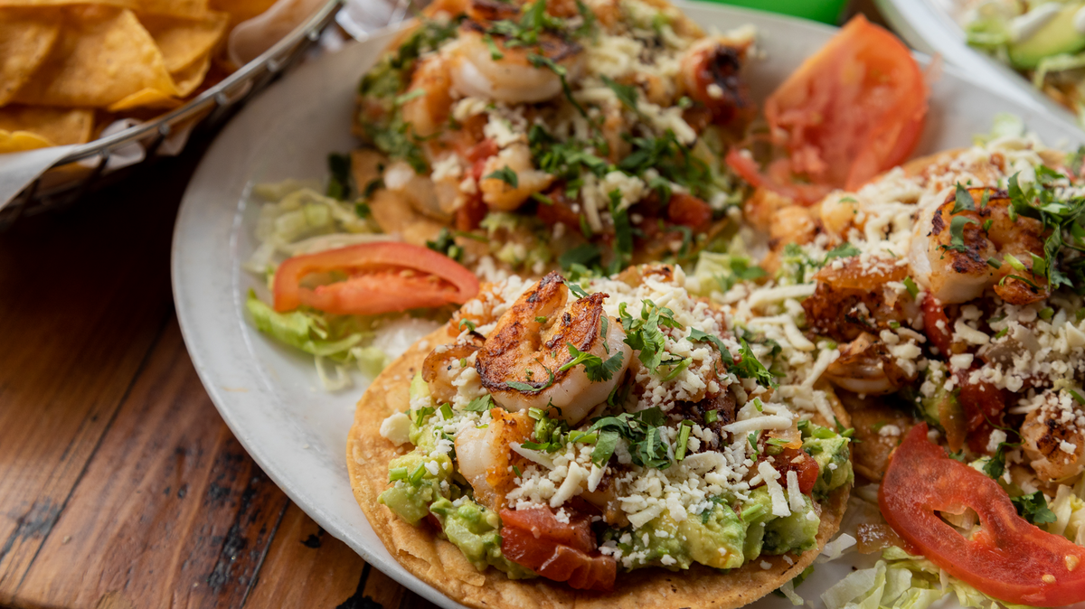 The Shrimp Tostada comes with fried tortillas topped with shrimp, lettuce, tomato, cheese, sour cream and guacamole.
