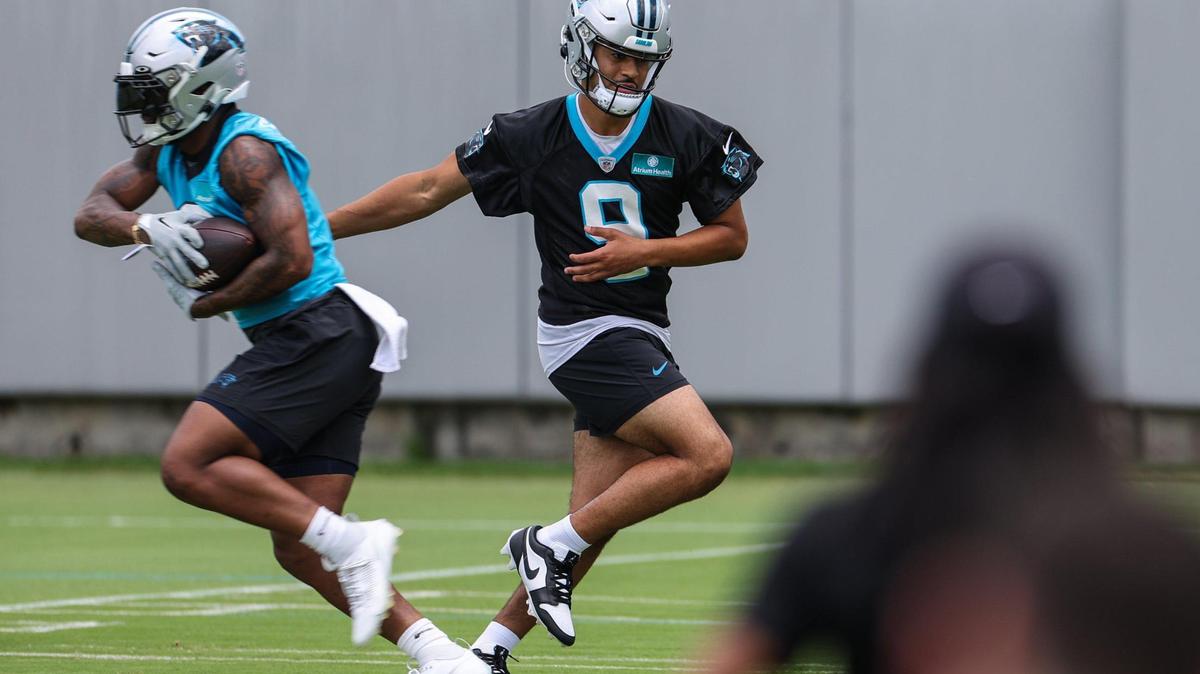 Panthers quarterback Bryce Young, right, hands the ball off to a running back during the first day of mandatory mini camp on Tuesday, June 13, 2023 at the practice fields behind Bank of America Stadium.