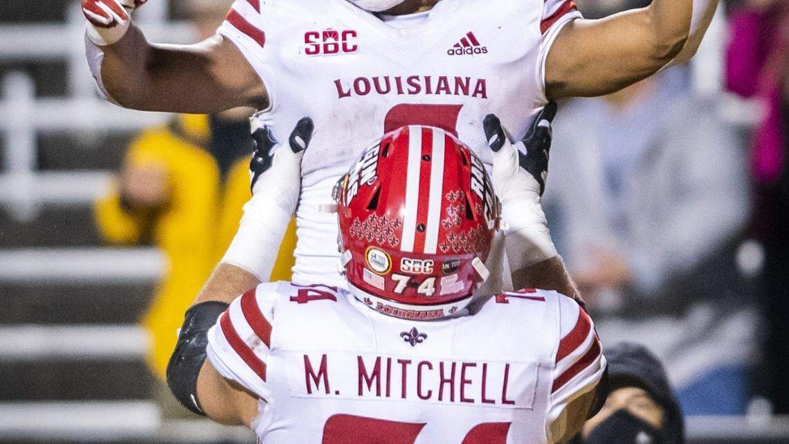 Louisiana running back Trey Ragas, top, celebrates after running for a touchdown against Appalachian State with offensive lineman Max Mitchell (74) during an NCAA college football game Friday, Dec. 4, 2020, in Boone, N.C. (Andrew Dye/The Winston-Salem Journal via AP)