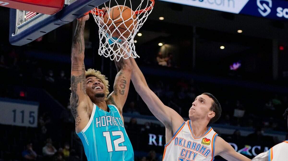 Charlotte Hornets guard Kelly Oubre Jr. (12) dunks in front of Oklahoma City Thunder forward Aleksej Pokusevski (17) in the first half of a preseason NBA basketball game Monday, Oct. 4, 2021, in Oklahoma City. (AP Photo/Sue Ogrocki)
