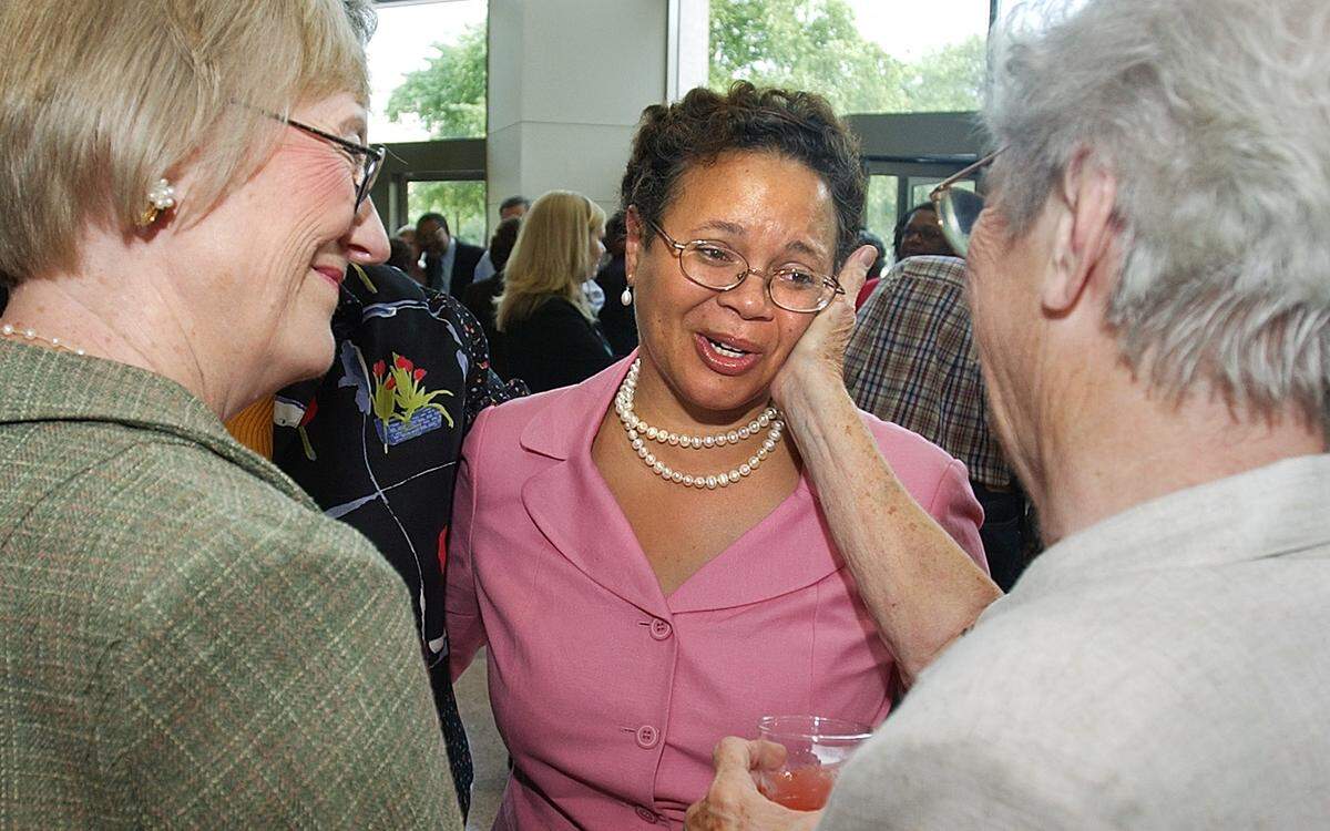 08/25/04: After almost 29 years in city government, Vi Lyles (CQ, center in pink) is retiring. She greeted many current and past government employees like Nancy Gilbert (CQ, left retired asst. city clerk) and Ruth Armstrong (CQ, right her hand is touching lyles face, retired city clerk). The assistant city manager is one of Pam Syfert's (CQ right in white applauding at the end of the ceremony.)most trusted lieutenants and one of the most respected voices in local government.   (JOHN D. SIMMONS/STAFF)