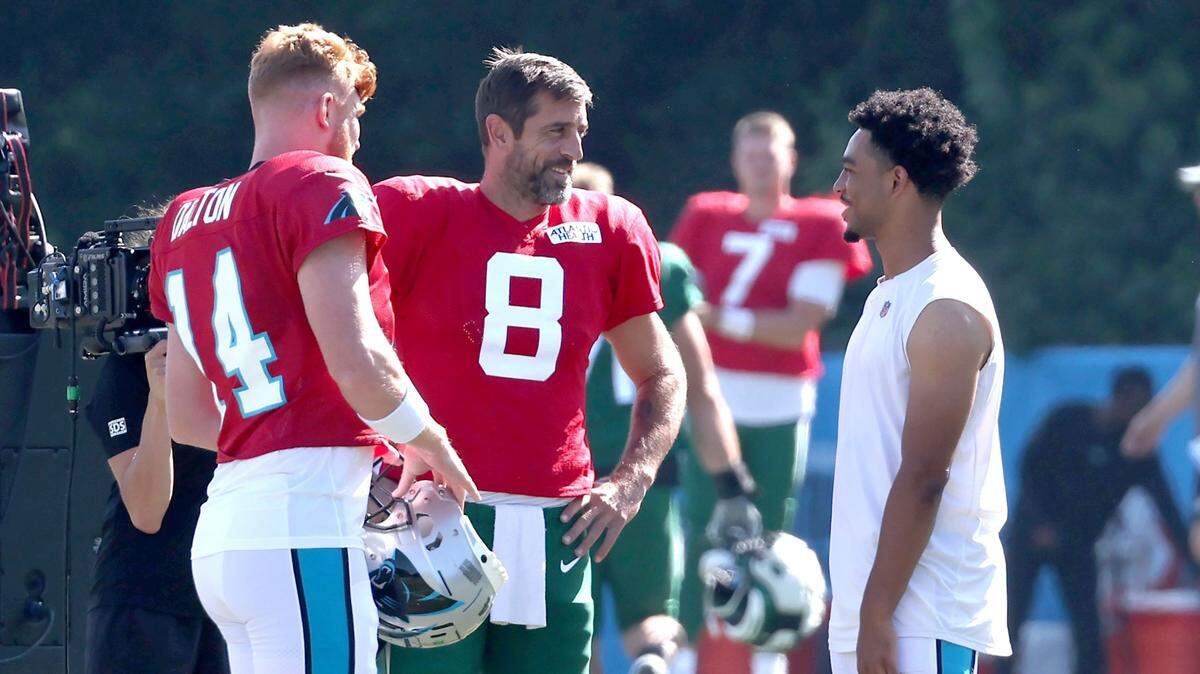Carolina Panthers quarterbacks Andy Dalton, left, New York Jets quarterback Aaron Rodgers, center and Bryce Young, right, talk prior to Wednesday’s team’s joint practice at Wofford College in Spartanburg, S.C.